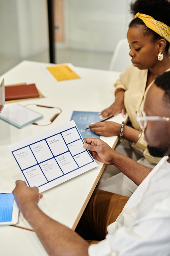 Two professionals analyzing documents during a collaborative team meeting in a modern office.
